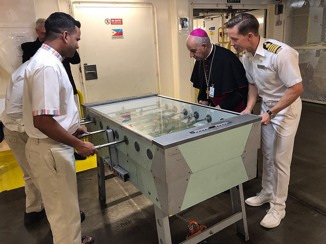 Archbishop Fisichella enjoys a game of foosball with the crew